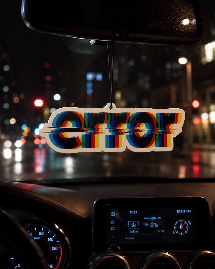 A die-cut acrylic car air freshener spelling 'ERROR' with a 3D glitch effect, hanging from the rearview mirror in a car on a rainy night.