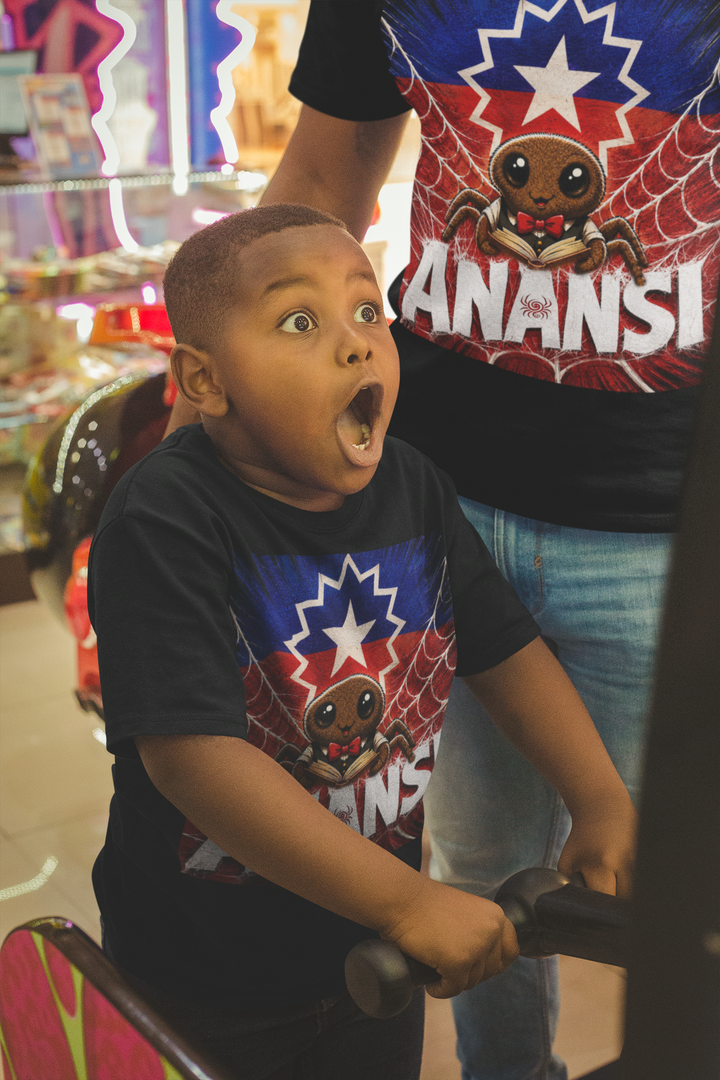 Child wearing a shirt with a superhero design, standing in front of a person wearing a 'Anansi' shirt.